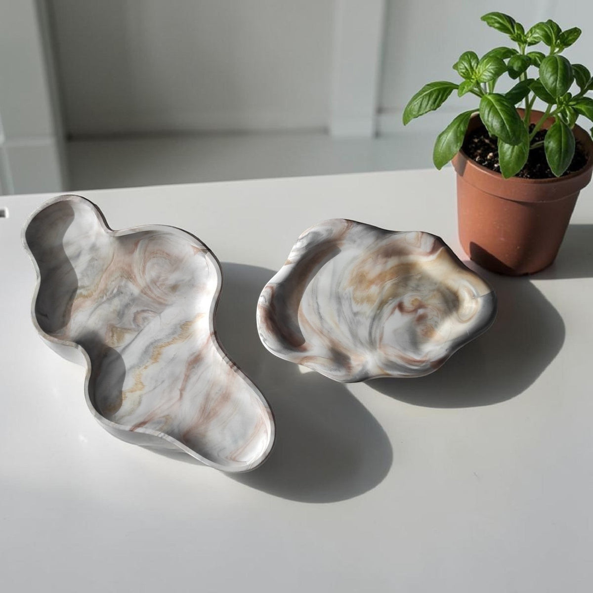 Bandejas decorativas AIKO con forma de nube en resina efecto mármol blanco y gris sobre mesa blanca