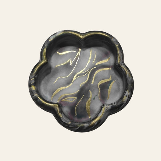 Bandeja decorativa AIKO con forma de flor en tonos oscuros veteados y detalles pintados en dorado brillante.
