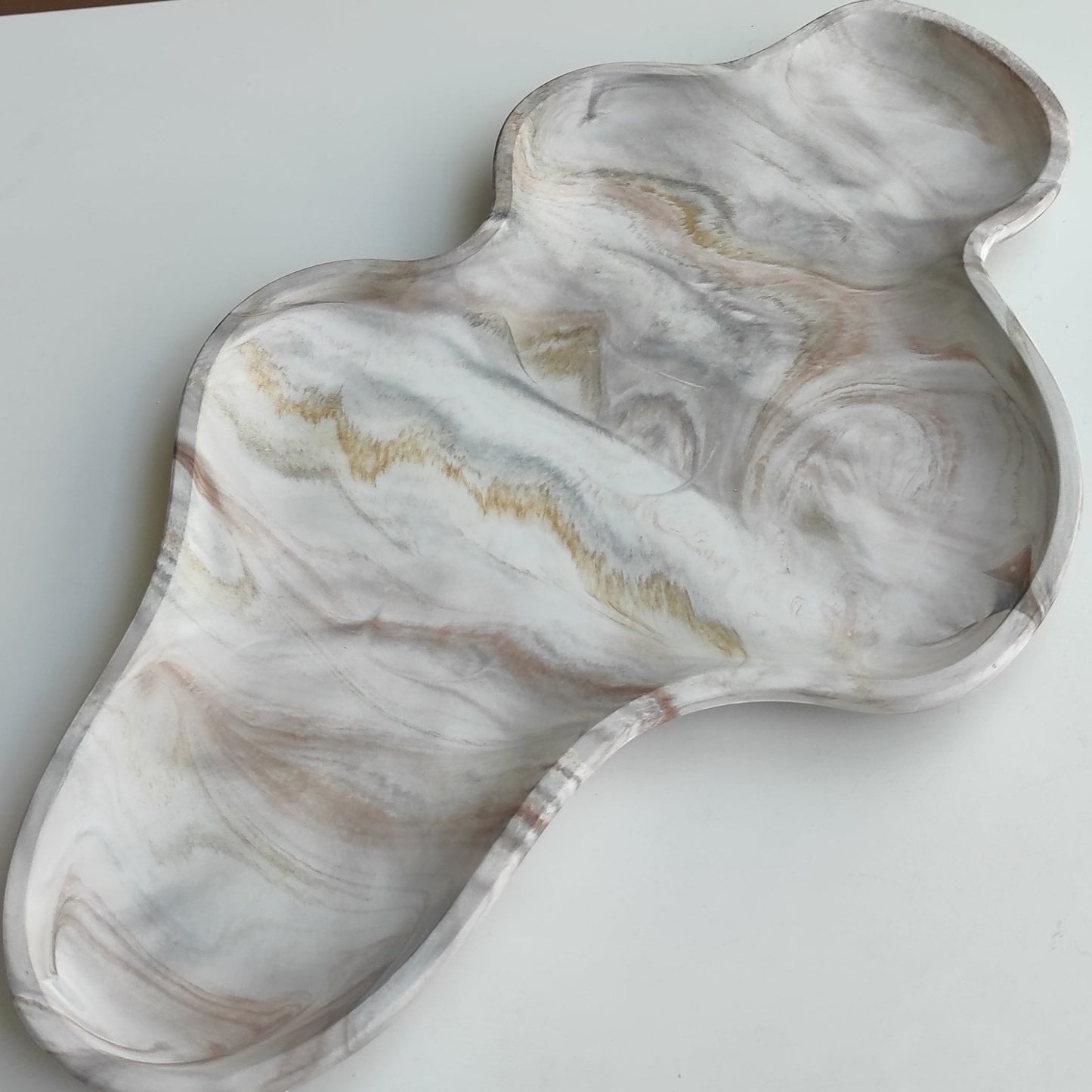 Bandeja decorativa AIKO con forma de nube irregular, acabado en resina efecto mármol blanco, gris y tonos dorados.