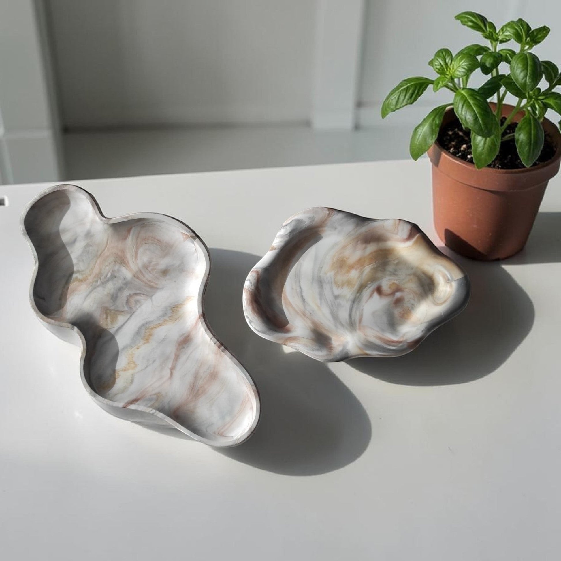 Bandejas decorativas AIKO con forma de nube en resina efecto mármol blanco y gris sobre mesa blanca