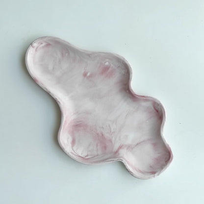Bandeja decorativa AIKO con forma de nube irregular, fabricada en resina con acabado efecto mármol en tonos rosa y blanco.