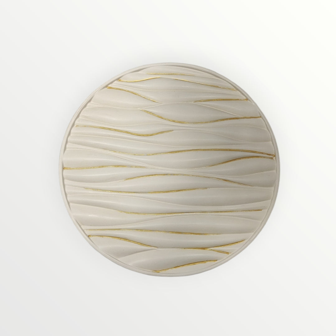 Plato decorativo AIKO circular en color crema con relieve ondulado y detalles en líneas doradas para pared o mesa
